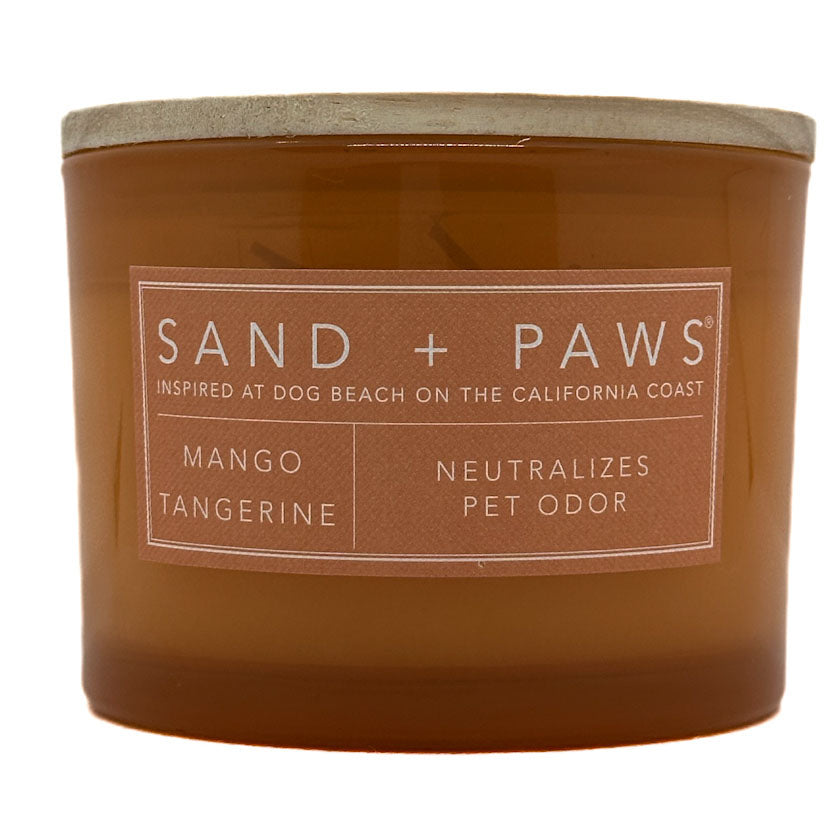 Mango Tangerine brown candle with 'Sand + Paws' label on a white background