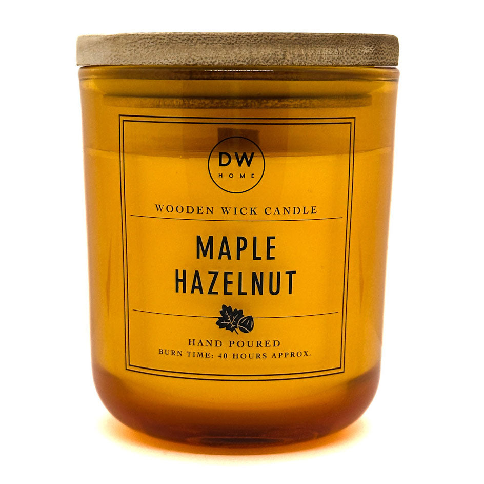 A DW Home Maple Hazelnut scented wooden wick candle in a translucent amber glass jar with a textured beige lid, shown against a plain white background.
