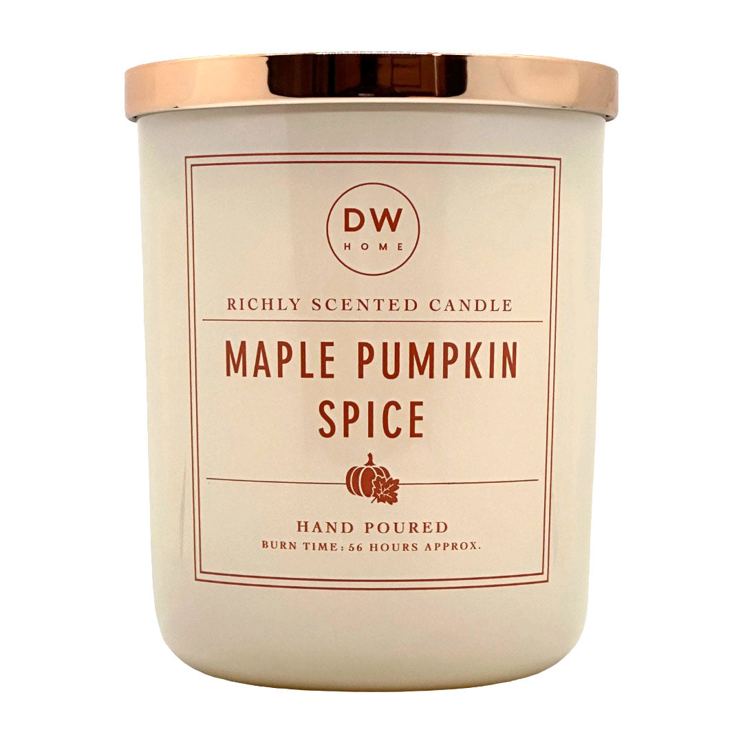 A beige glass jar candle with a metallic rose gold lid. The label features the brand 'DW HOME' and the scent name 'MAPLE PUMPKIN SPICE' in dark red letter.