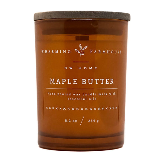 An amber glass jar candle with a dark gray lid, labeled 'Charming Farmhouse DW Home Maple Butter' on a white background.