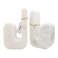 White marble bookends in the form of the letter 'J'