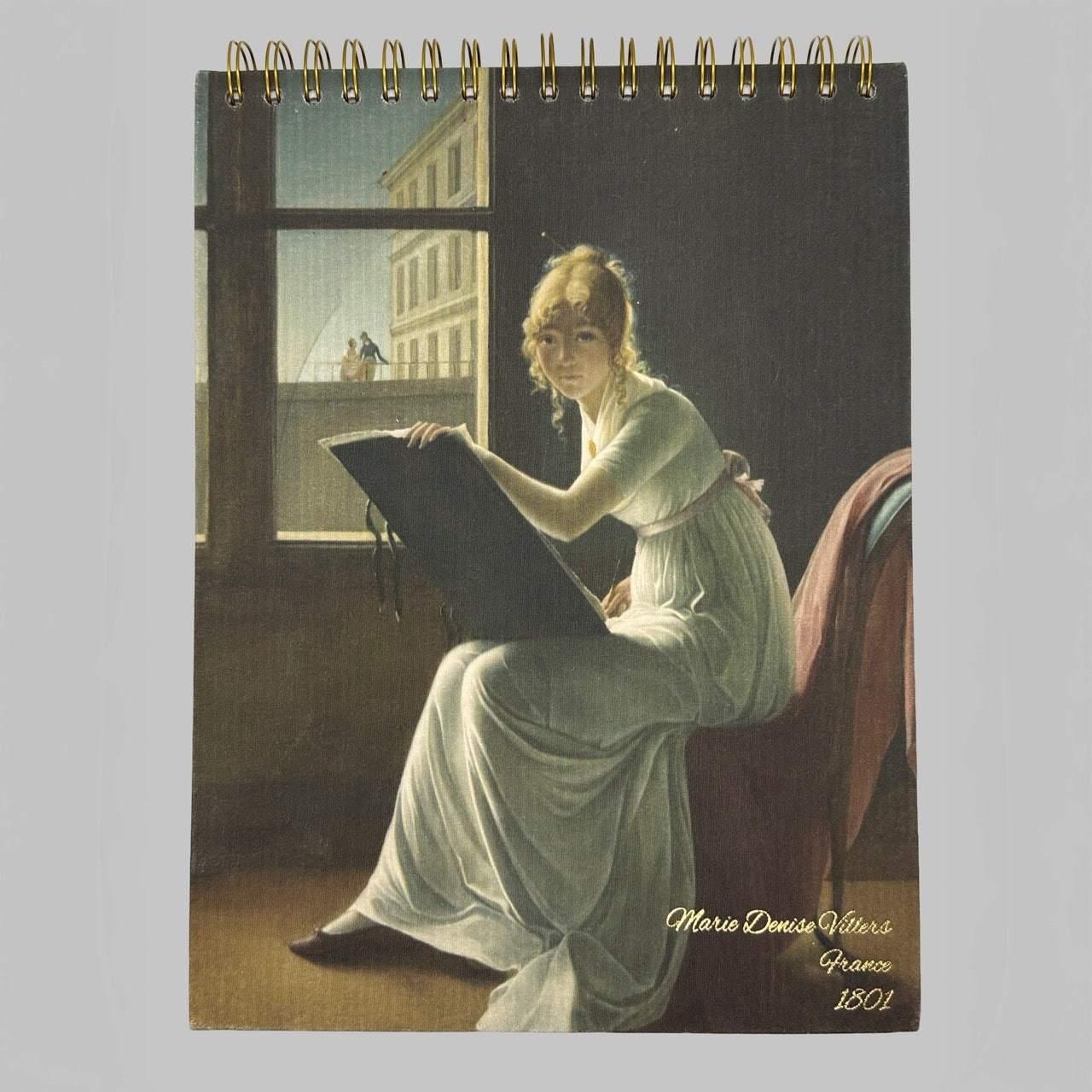 Notebook with a painting of a woman sitting by a window, holding a book, on the cover.