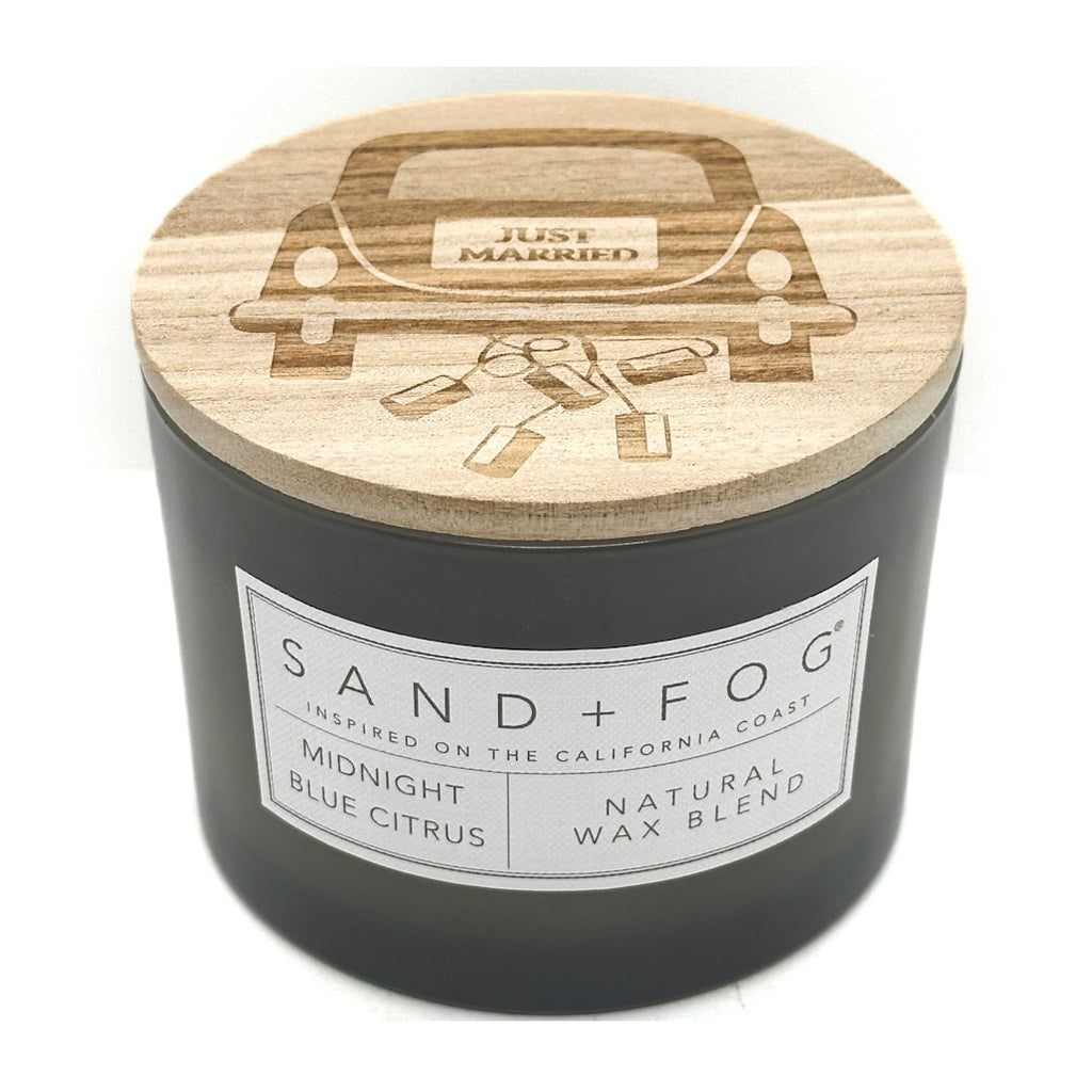 Grey candle with a wooden lid featuring 'Just Married' design, branded 'Sand + Fog'.