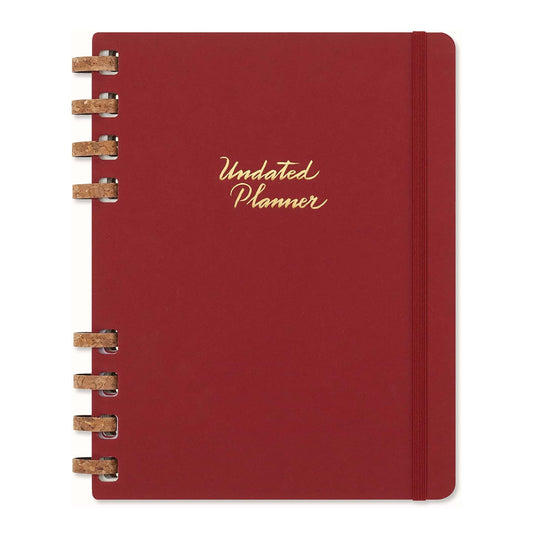 Moleskine red planner with gold text on a white background.