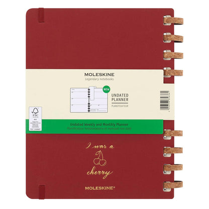 Moleskine planner with red cover and beige label on a white background