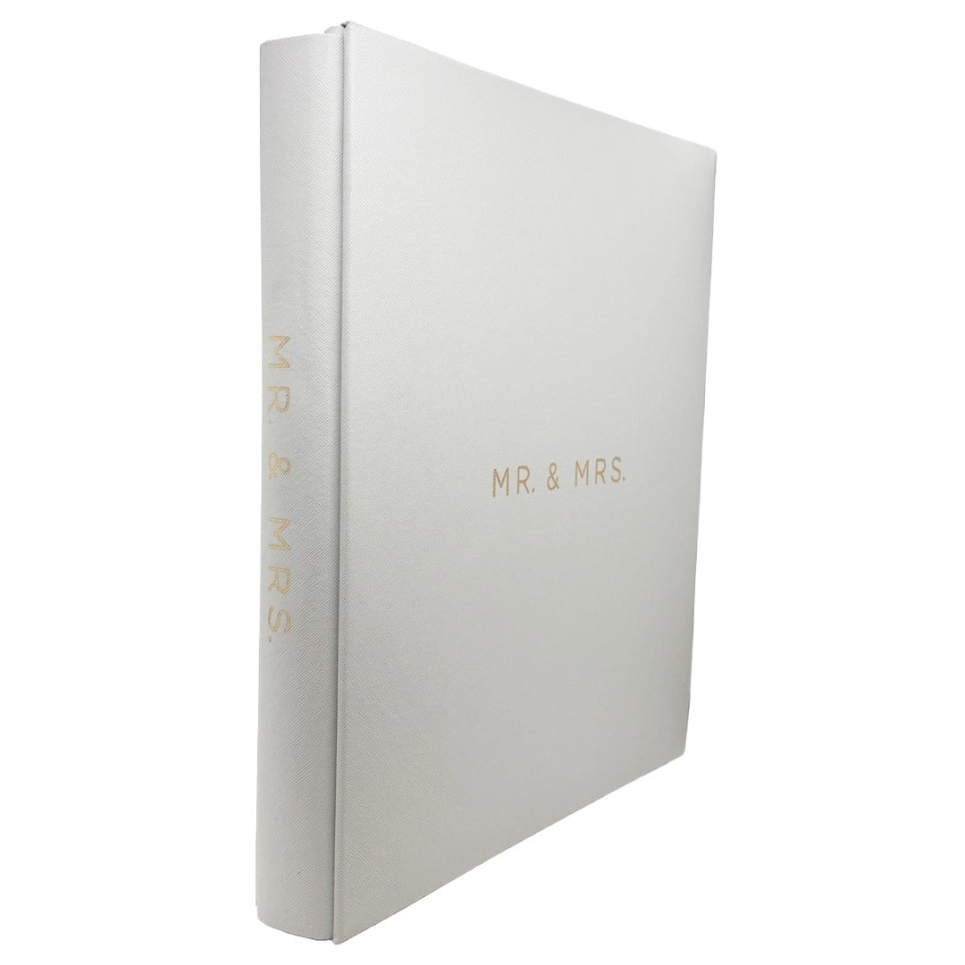 A white hardcover photo album with gold foil lettering reading 'MR. & MRS.