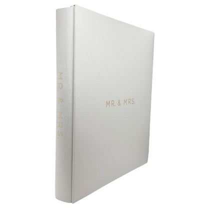 A white hardcover photo album with gold foil lettering reading 'MR. & MRS.