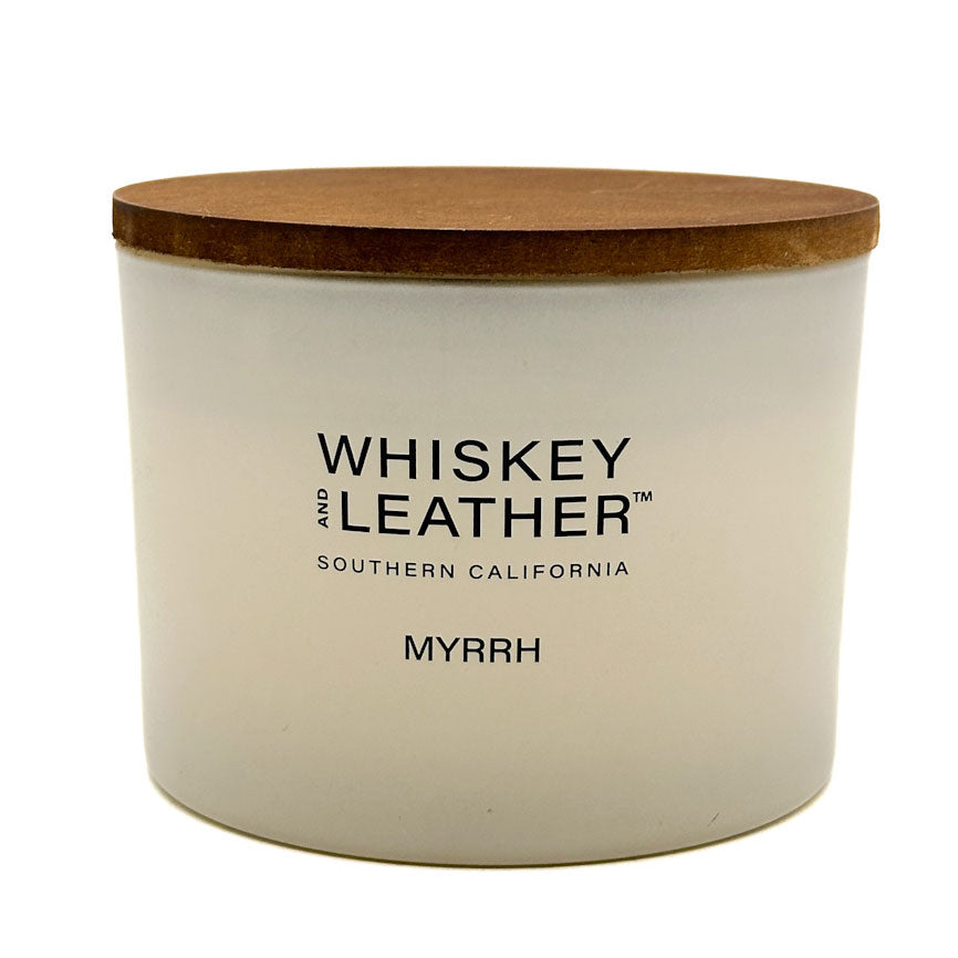 Myrrh scented candle with wooden lid labeled 'Whiskey and Leather' on a white background