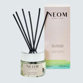 Neom reed diffuser with packaging on a light gray background
