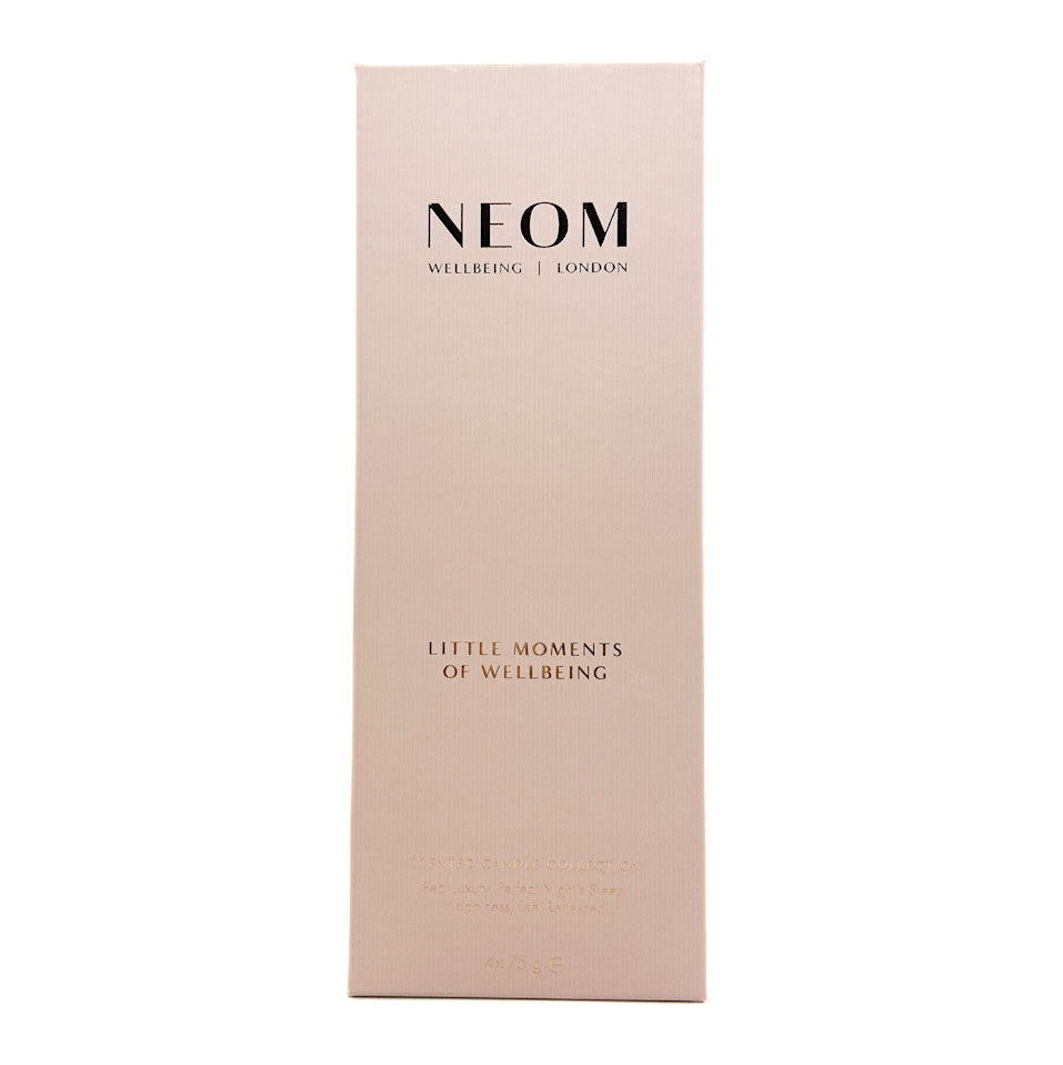 A tall, narrow pale blush pink box with black and rose-gold text reading 'NEOM WELLBEING | LONDON' and 'LITTLE MOMENTS OF WELLBEING', centered on a white background.