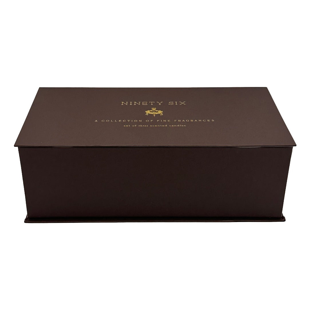 A dark brown rectangular presentation candle gift box with a lid, featuring gold foil text that reads 'NINETY SIX' and 'A COLLECTION OF FINE FRAGRANCES' on a plain white background.