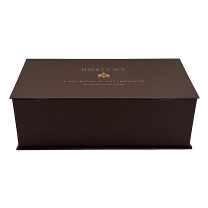 A dark brown rectangular presentation candle gift box with a lid, featuring gold foil text that reads 'NINETY SIX' and 'A COLLECTION OF FINE FRAGRANCES' on a plain white background.