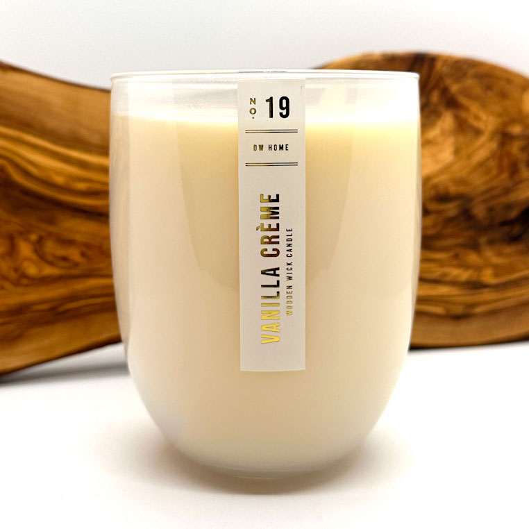 DW Home Vanilla Crème candle with a wooden bowl in the background