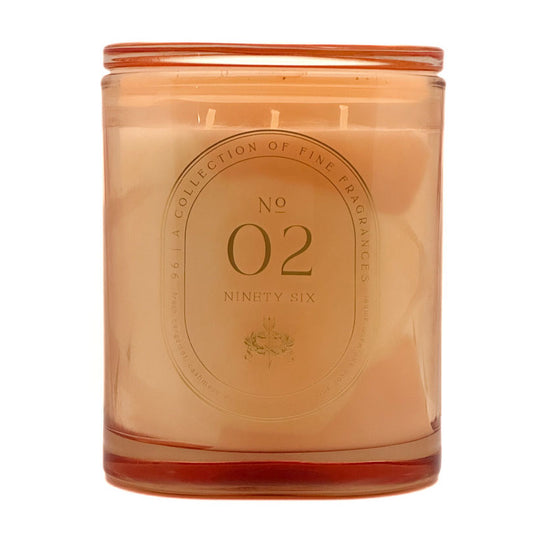An amber glass jar candle with a matching amber lid, filled with pale peach wax. The front features a circular embossed label reading 'No 02 Ninety Six' and 'A Collection of Fine Fragrances'.