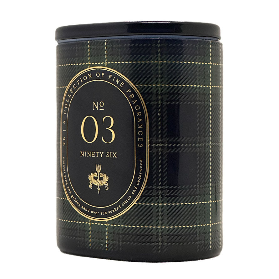 A cylindrical scented candle tin with a black lid and a black plaid patterned body, featuring a large gold oval label that reads 'No 03 Ninety Six' and 'A Collection of Fine Fragrances'.
