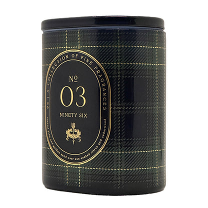 A cylindrical scented candle tin with a black lid and a black plaid patterned body, featuring a large gold oval label that reads 'No 03 Ninety Six' and 'A Collection of Fine Fragrances'.