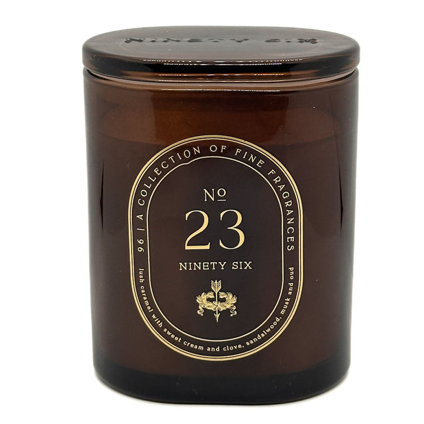 A dark amber glass jar candle with a gold circular label reading 'No. 23 Ninety Six' and 'A Collection of Fine Fragrances'.