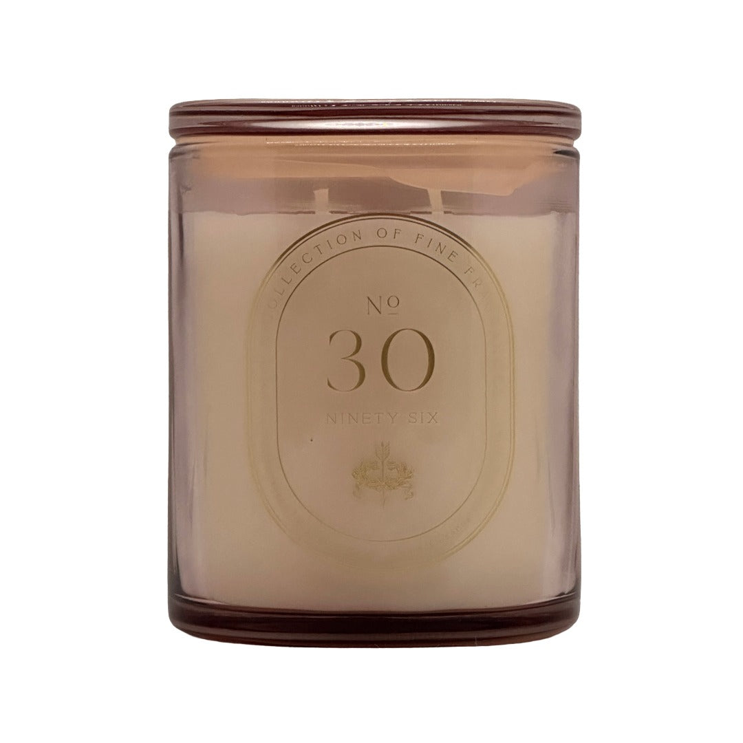 A No. 30 DW Home scented candle in a translucent amber glass jar with a cream-coloured wax and a gold-toned oval label on the front.