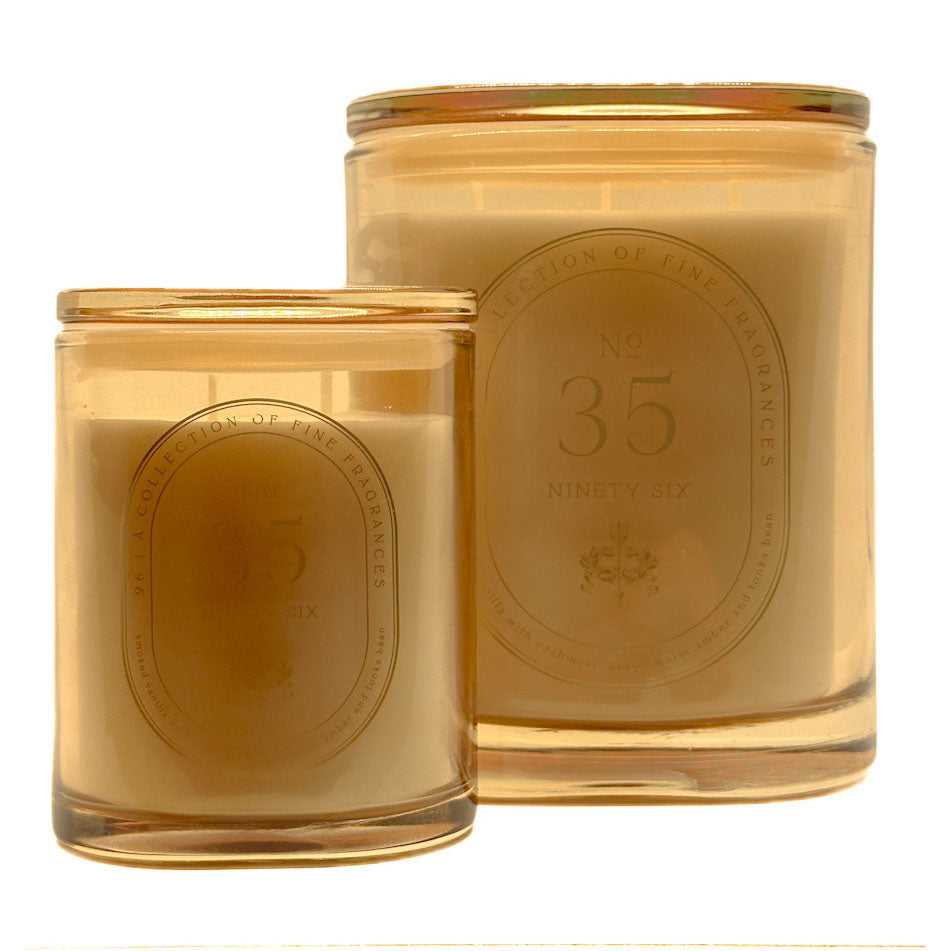 Two amber glass jar DW Home candles with cream-coloured wax and embossed oval labels reading 'No. 35 Ninety Six' and 'Section of Fine Fragrances', shown on a white background.