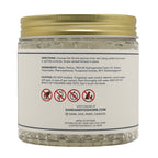 A clear plastic jar of Sand and Fog Home BHT Ethylhexyrgron candle beads with a gold screw-on lid and a white label showing product directions and ingredients.