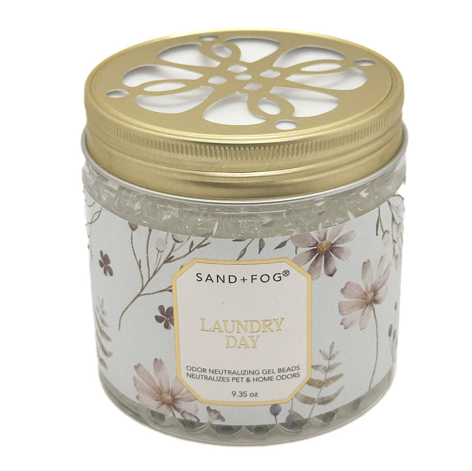 A jar of Sand + Fog Laundry Day odour neutralising gel beads with a gold perforated lid and a floral-patterned label, set against a plain white background.