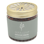 A jar of Sand + Fog Pistachio Dream odour neutralising gel beads, featuring a metallic gold lid with a decorative cutout and a muted grey-green label.