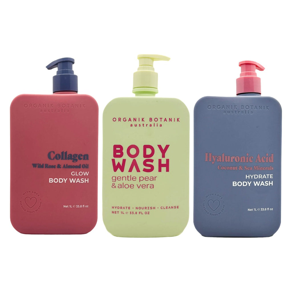 Three body wash bottles from Organik Botanik Australia lined up against a white background: a coral pink bottle labeled Collagen, a pale yellow-green bottle labeled BODY WASH, and a slate blue bottle labeled Hyaluronic Acid.