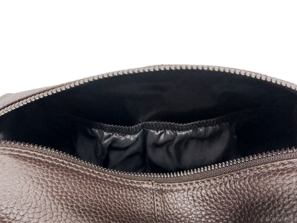 Close-up of a brown leather bag with a zipper, showing the interior.