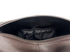Close-up of a brown leather bag with a zipper, showing the interior.