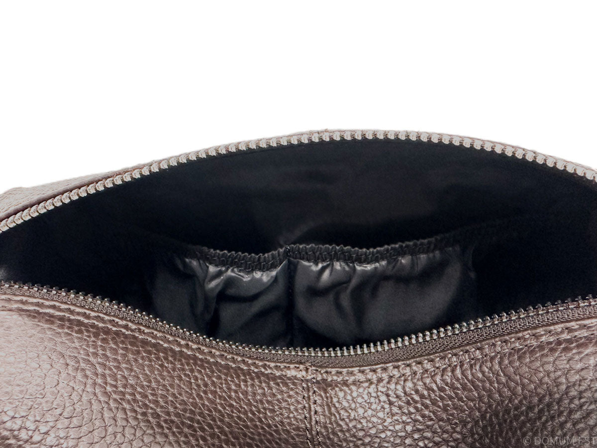 Close-up of a brown leather bag with a zipper, showing the interior.