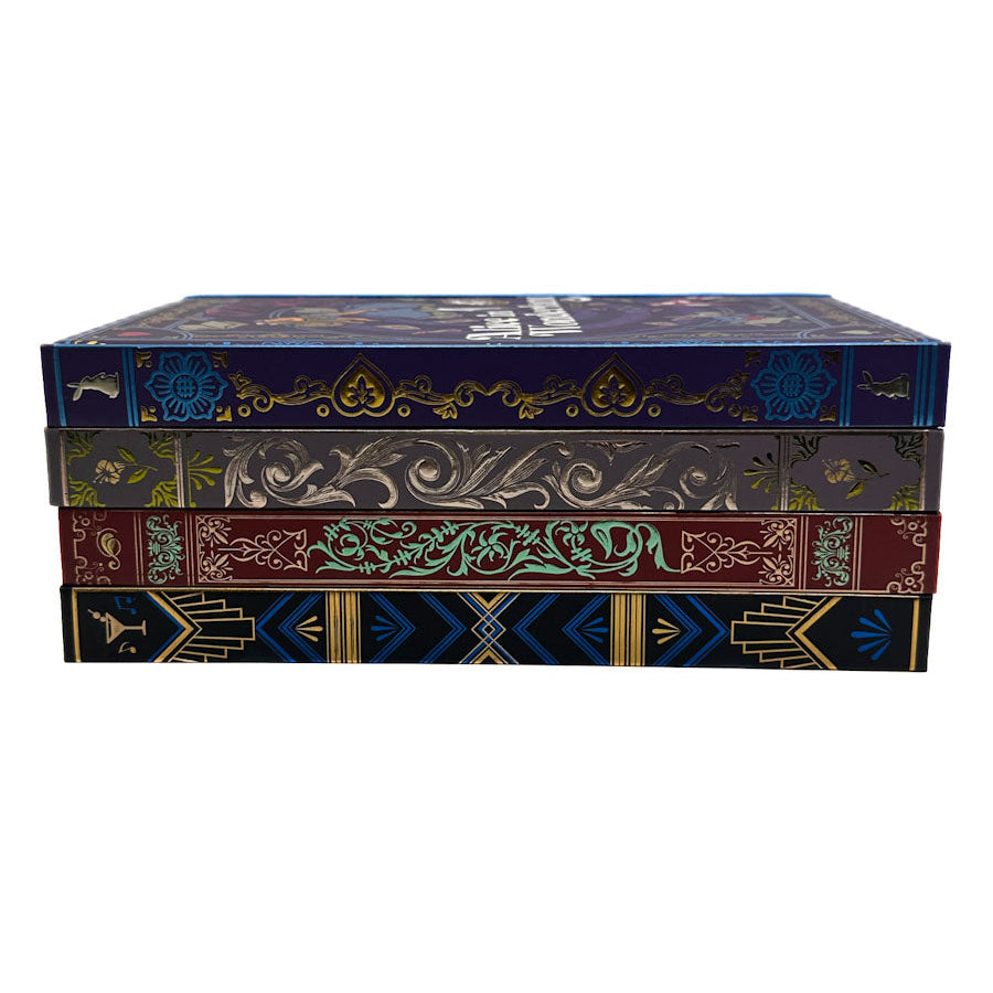 A stack of four decorative book-style boxes with ornate embossed or printed spines in dark blue, olive green, burgundy, and black, featuring gold and teal detailing, on a plain white background.