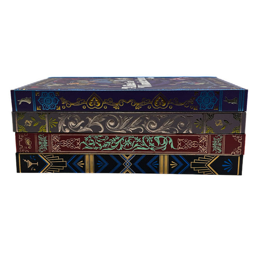 A stack of four decorative book-style boxes with ornate embossed or printed spines in dark blue, olive green, burgundy, and black, featuring gold and teal detailing, on a plain white background.
