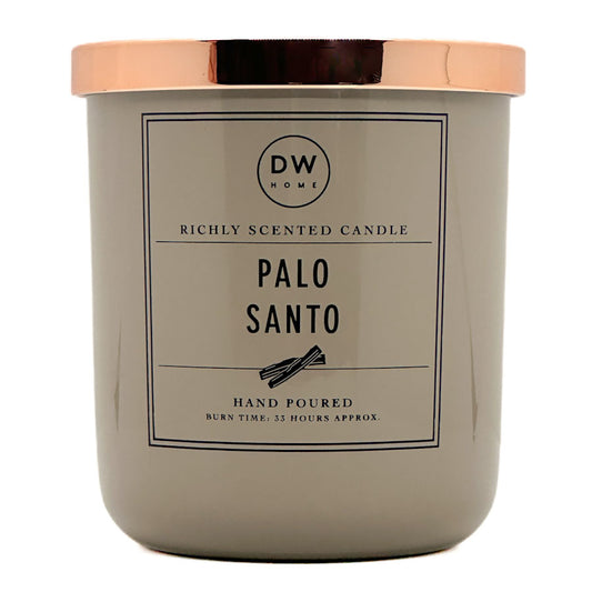 A candle jar with a matte taupe-gray body and a metallic rose gold lid, featuring a front label that reads 'DW HOME' and 'PALO SANTO'.