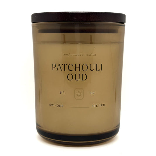 Candle jar labeled 'Patchouli Oud' by DW Home on a white background