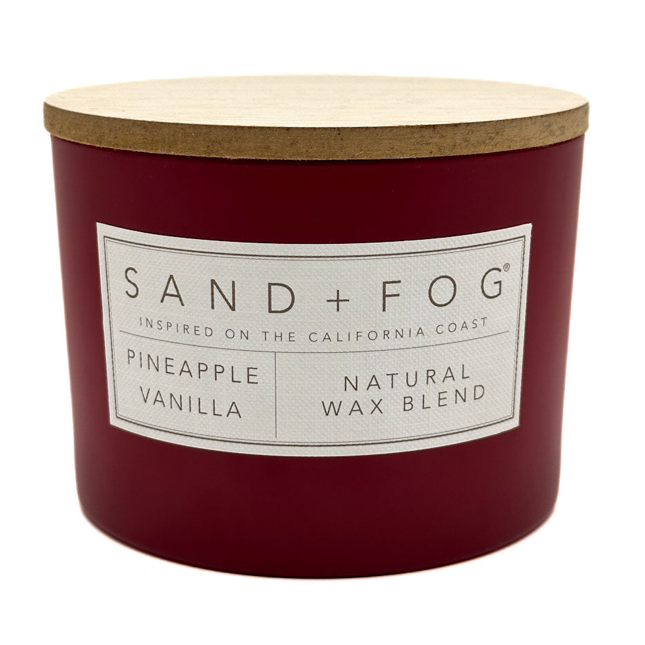Pineapple vanilla Red candle with a wooden lid labeled 'Sand + Fog' on a white background