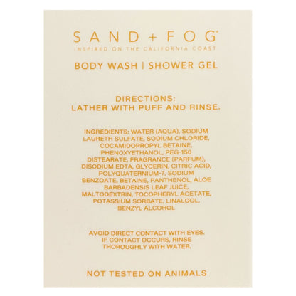 A beige rectangular card with orange text reading 'SAND + FOG' and 'BODY WASH | SHOWER GEL,' plus directions and ingredients, photographed against a white background.