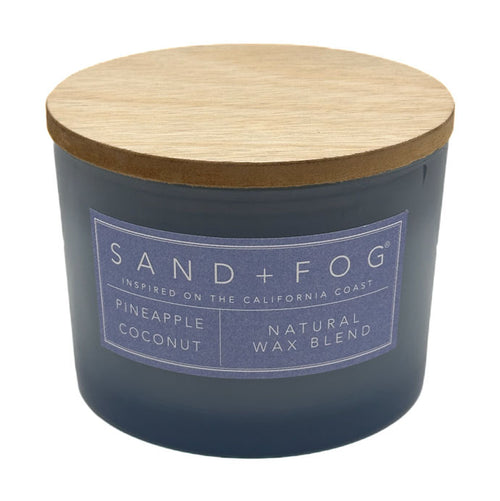 Pineapple Coconut candle with a wooden lid labeled 'Sand + Fog' on a white background