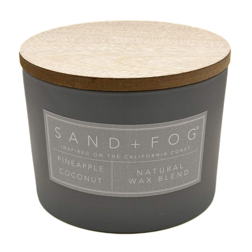 Pineapple Coconut Grey candle with wooden lid and 'Sand + Fog' label on a white background