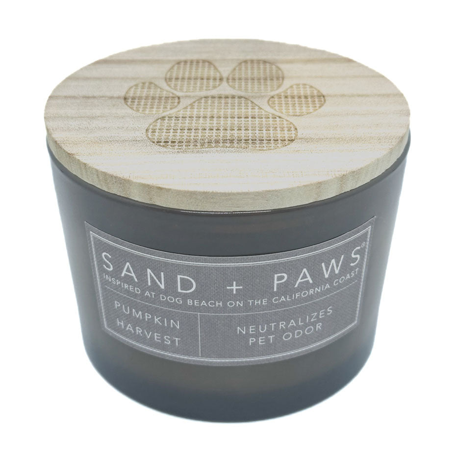 Pumpkin Harvest Candle with wooden lid featuring paw prints and 'Sand + Paws' branding on a white background.