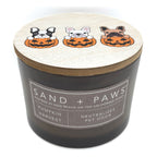 Pumpkin Harvest candle with 'Sand + Paws' label and Halloween-themed lid featuring dogs in pumpkins on a white background.
