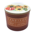 Pumpkin Spice Candle with a decorative lid featuring pumpkins and sunflowers, branded as Sand + Fog.