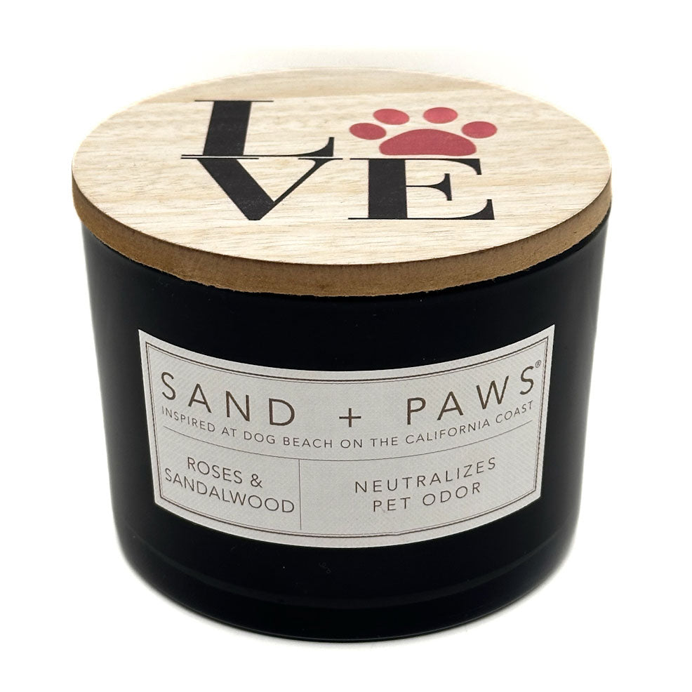 Roses & Sandalwood Black candle with a wooden lid featuring 'LOVE' and paw prints, branded 'Sand + Paws'.