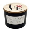 Roses & Sandalwood Black candle with a wooden lid featuring 'LOVE' and paw prints, branded 'Sand + Paws'.