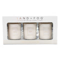Three candles in a box with 'Sand + Fog' branding on a white background