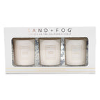 Three candles in a box with 'Sand + Fog' branding on a white background