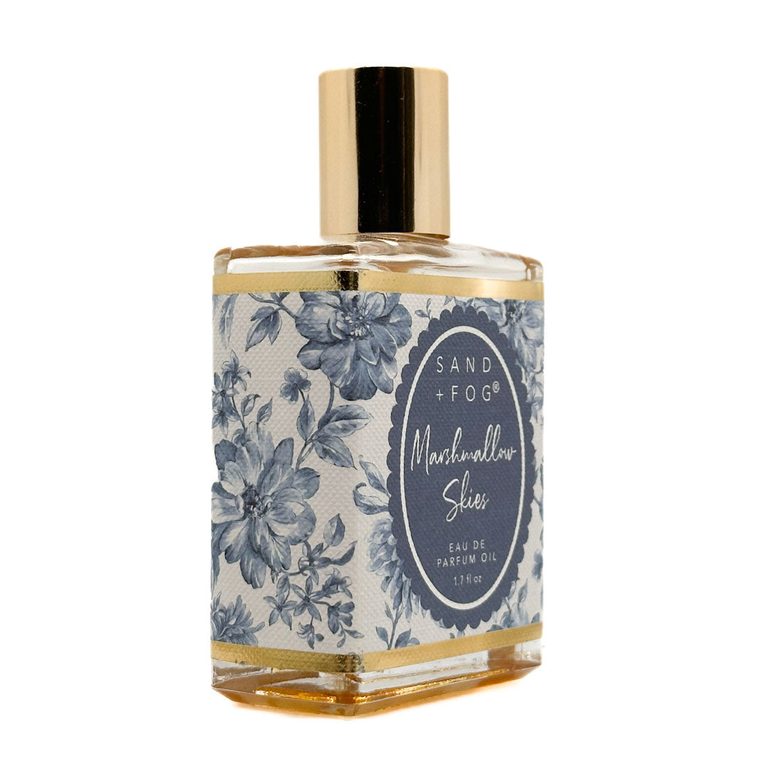 SAND + FOG Eau De Parfum Oil bottle with floral design and gold accents on a white background