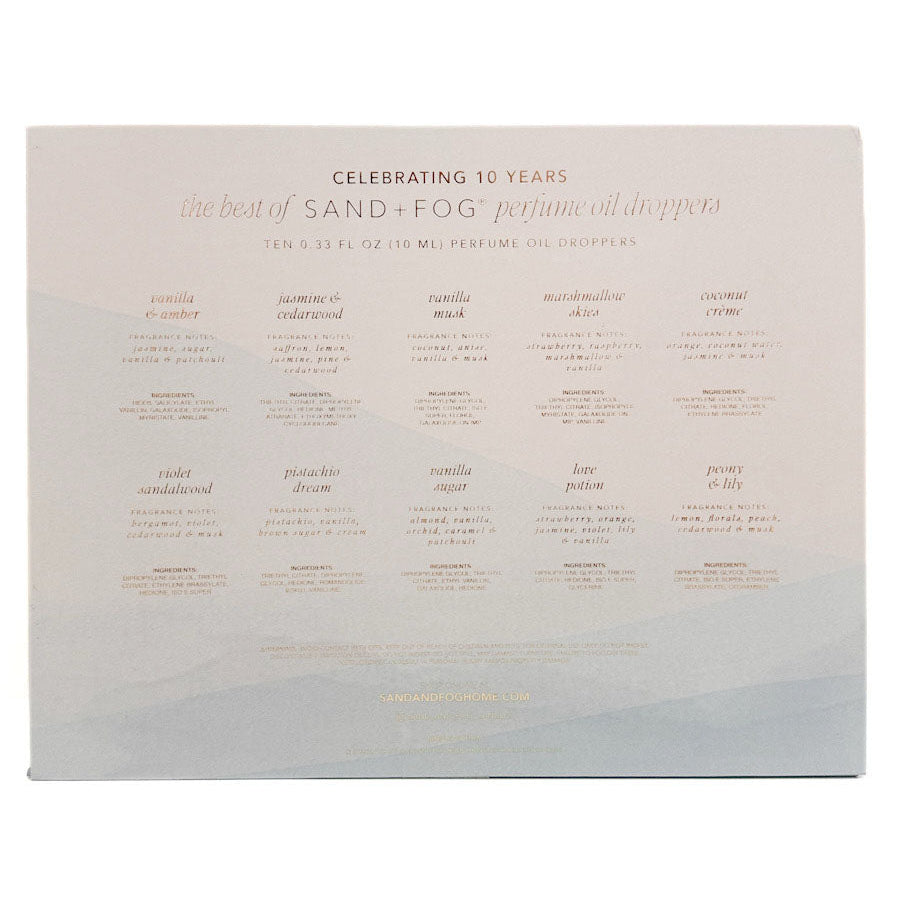 SAND + FOG Perfume oil discovery set contents with small rose-gold text reading 'Celebrating 10 Years' and 'the best of SAND + FOG perfume oil droppers.