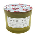 Sandalwood Verbena Olive Green candle with floral lid labeled 'Namaste' by Sand + Fog' on a white background