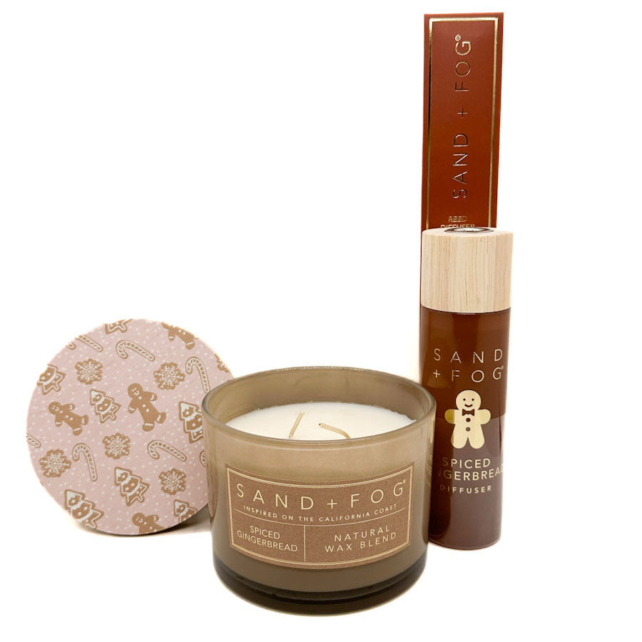 Candle and reed diffuser with 'Sand + Fog' branding on a white background