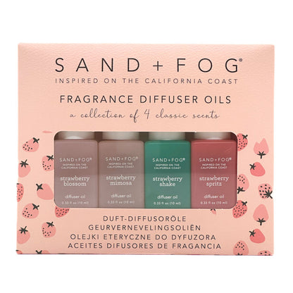 Sand + Fog fragrance diffuser oils set on a pink packaging with strawberry design